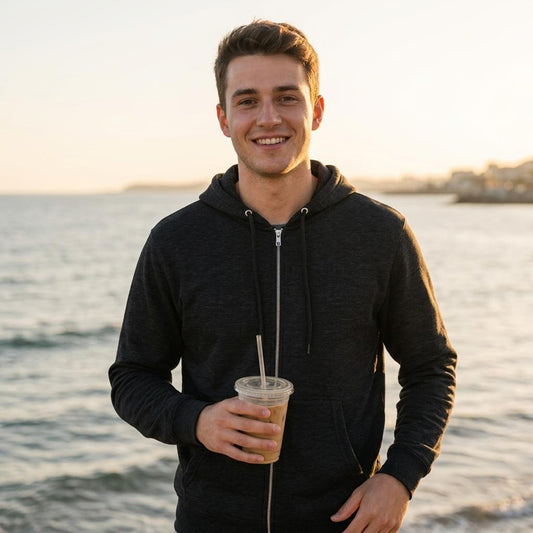 Café Valhall Zip Hoodie i Black – mann forfra ved havn i solnedgang – Nordic Hoodies